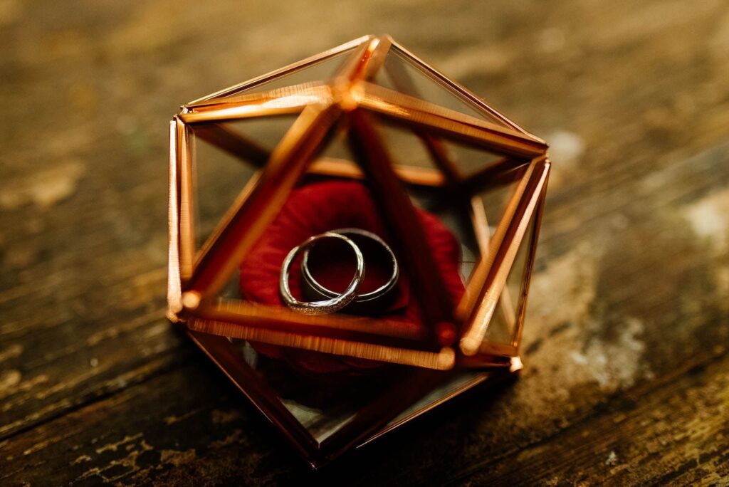 A geometric copper frame box with wedding rings