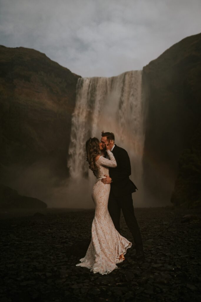 Bride and groom in a wedding photo with Skogafoss waterfall in Iceland
