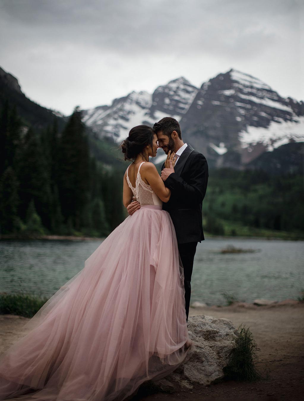 Newly married couple posing for wedding photos at Maroon Bells in Colorado